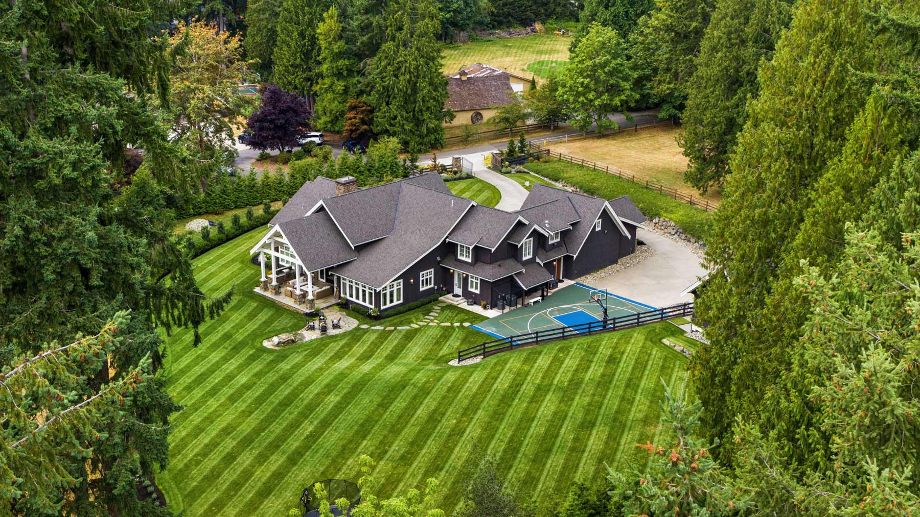 Woodinville Luxury estate arial drone photo of huge green grass and luxury home with text saying WOODINVILLE